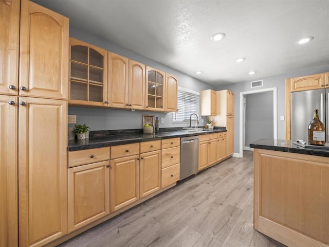 kitchen with visible vents, light brown cabinets, light wood-style floors, glass insert cabinets, and appliances with stainless steel finishes