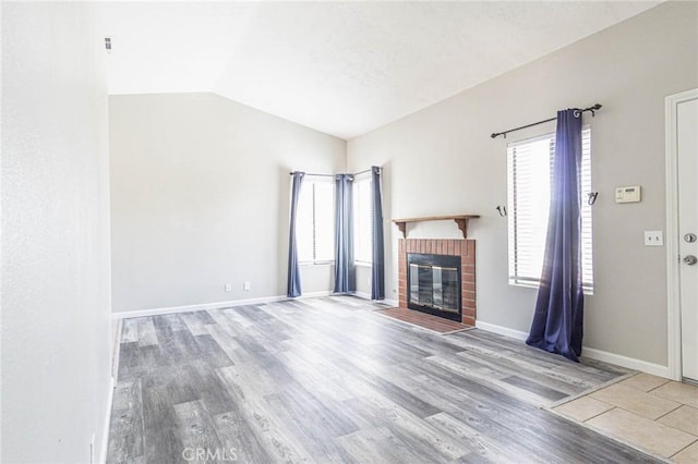 14292 Pinewood Dr, Hesperia, CA 92344 - unfurnished living room with baseboards, vaulted ceiling, wood finished floors, and a brick fireplace