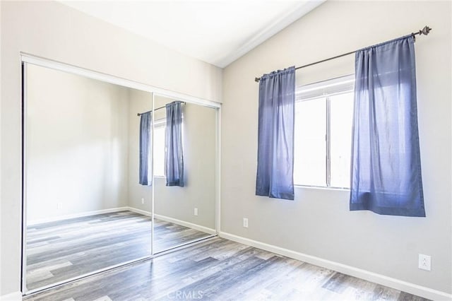 14292 Pinewood Dr, Hesperia, CA 92344 - unfurnished bedroom featuring wood finished floors, a closet, baseboards, and multiple windows