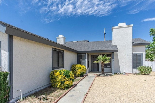 14292 Pinewood Dr, Hesperia, CA 92344 - doorway to property with fence, a chimney, and stucco siding