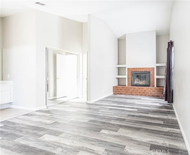 14292 Pinewood Dr, Hesperia, CA 92344 - unfurnished living room with visible vents, baseboards, wood finished floors, and a fireplace