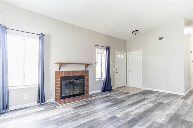 14292 Pinewood Dr, Hesperia, CA 92344 - unfurnished living room with baseboards, a brick fireplace, wood finished floors, and visible vents