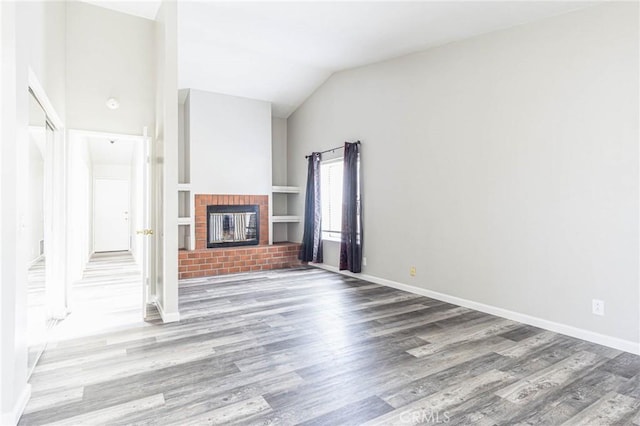 14292 Pinewood Dr, Hesperia, CA 92344 - unfurnished living room featuring a fireplace, wood finished floors, lofted ceiling, and baseboards