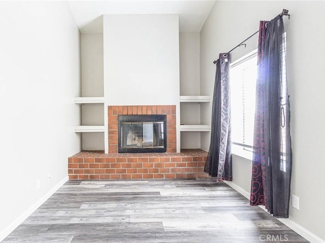 14292 Pinewood Dr, Hesperia, CA 92344 - unfurnished living room with wood finished floors, a brick fireplace, and baseboards