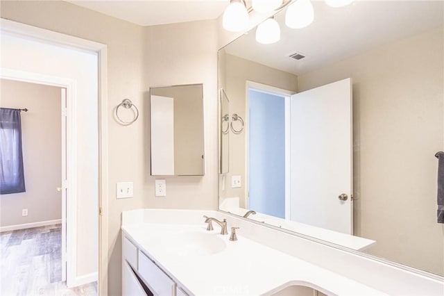 14292 Pinewood Dr, Hesperia, CA 92344 - bathroom featuring baseboards, wood finished floors, visible vents, and vanity