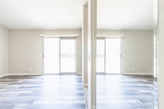 14292 Pinewood Dr, Hesperia, CA 92344 - empty room featuring baseboards, wood finished floors, and a healthy amount of sunlight