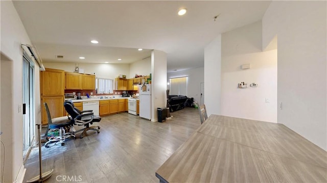 kitchen featuring white appliances, recessed lighting, wood finished floors, and light countertops