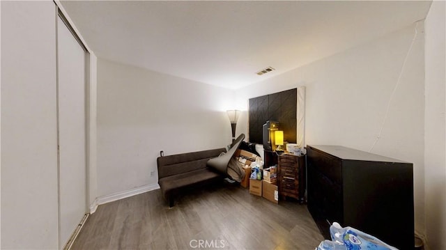 living area with visible vents and wood finished floors
