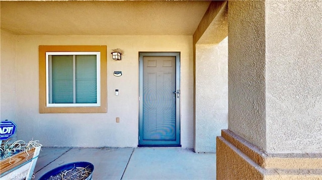 doorway to property featuring stucco siding