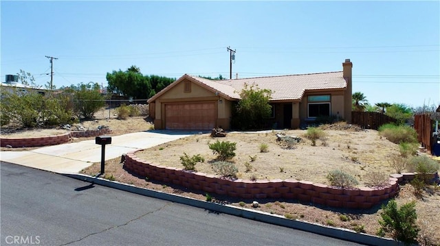 single story home featuring a garage, fence, stucco siding, a chimney, and concrete driveway