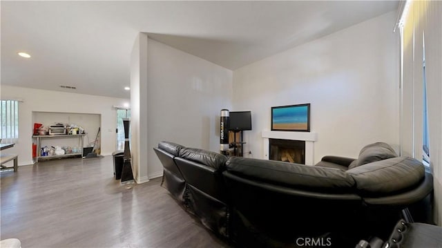 living room with baseboards, visible vents, wood finished floors, and a fireplace