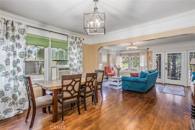 dining area featuring ornamental molding, wood finished floors, cooling unit, arched walkways, and a notable chandelier