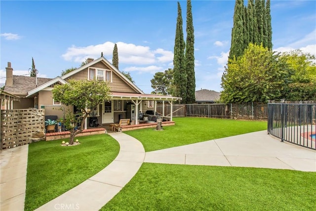 rear view of house featuring a porch, a chimney, a patio area, a fenced backyard, and a yard