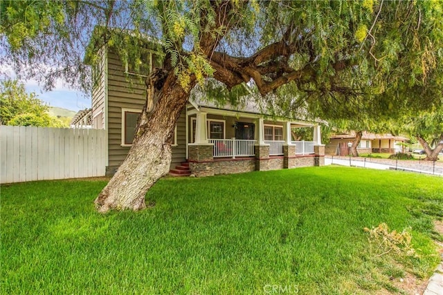 view of front facade with a porch, fence, and a front yard