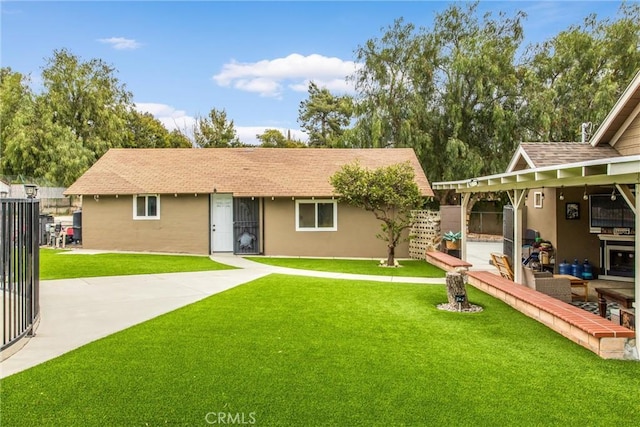 back of property with a yard, a patio, fence, and stucco siding