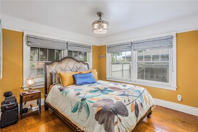 bedroom featuring baseboards and wood-type flooring