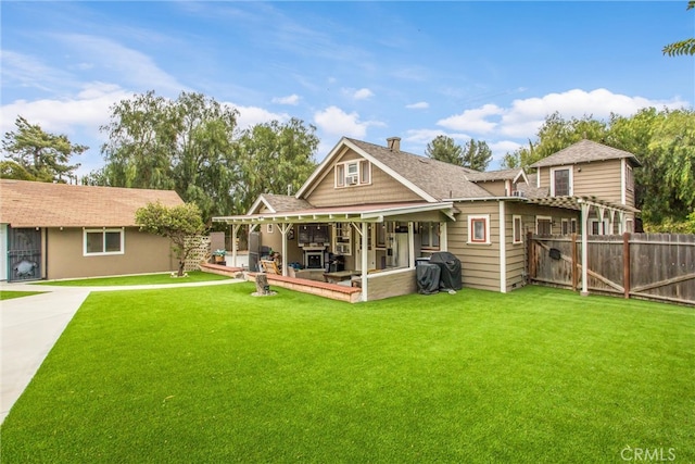 back of house featuring fence, a shingled roof, and a yard