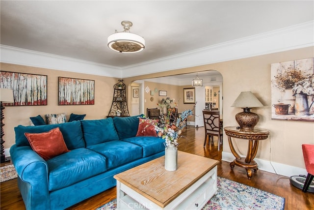 living area with crown molding, arched walkways, and wood finished floors