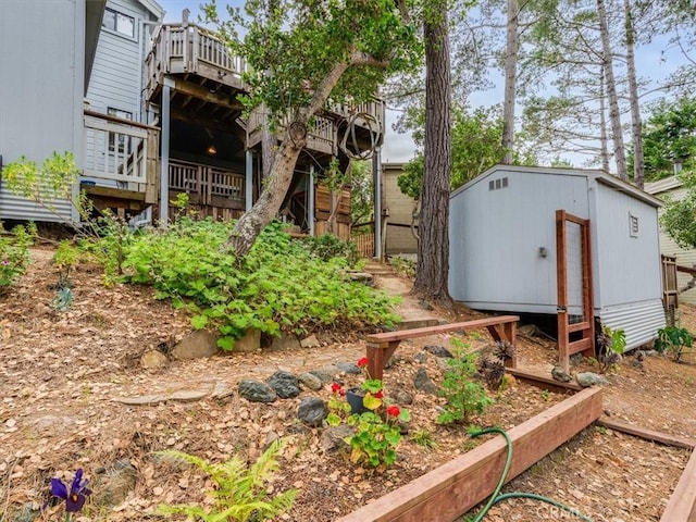 view of yard with a deck, an outdoor structure, and a shed