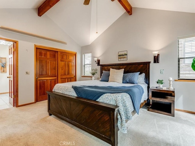 bedroom featuring beam ceiling, baseboards, light colored carpet, a closet, and high vaulted ceiling