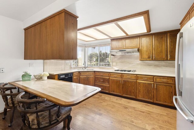 2409 Dehesa Rd, El Cajon, CA 92019 - kitchen with freestanding refrigerator, under cabinet range hood, dishwasher, gas stovetop, and a sink