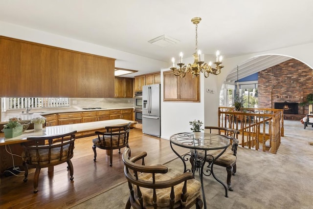 2409 Dehesa Rd, El Cajon, CA 92019 - dining area featuring a brick fireplace, an inviting chandelier, and light wood-type flooring