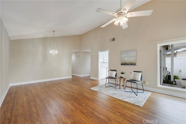 sitting room with baseboards, wood finished floors, high vaulted ceiling, and ceiling fan with notable chandelier