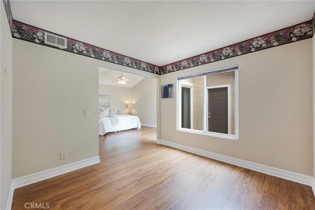unfurnished bedroom featuring visible vents, baseboards, and wood finished floors
