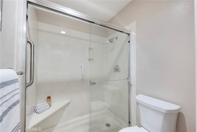 full bath with toilet and a stall shower