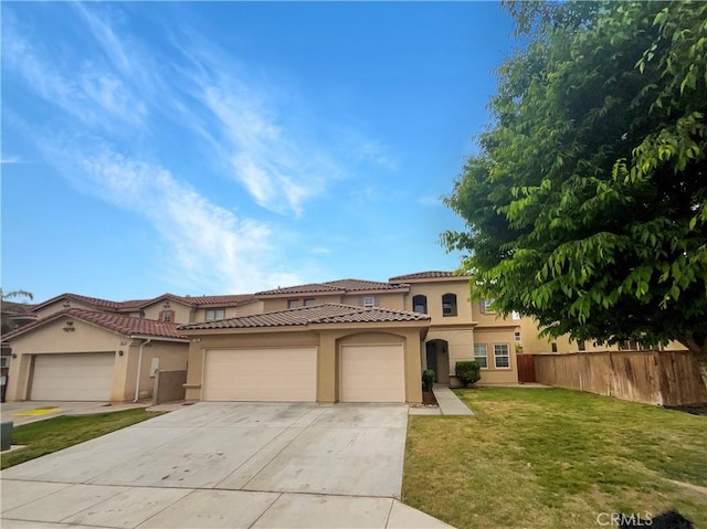 mediterranean / spanish house featuring stucco siding, a tiled roof, fence, driveway, and an attached garage