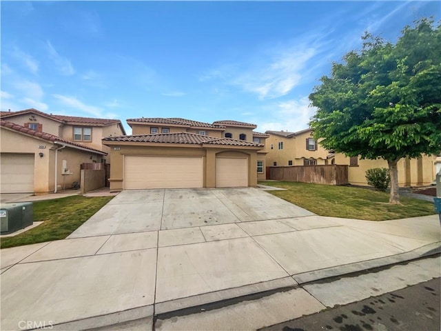 mediterranean / spanish-style home featuring a front lawn, stucco siding, concrete driveway, an attached garage, and fence