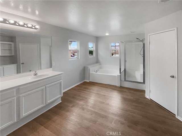 full bath with a bath, a shower stall, wood finished floors, and vanity