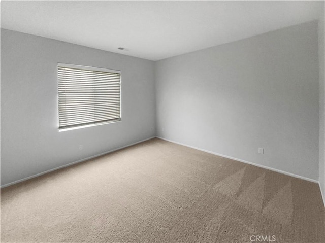 carpeted empty room with visible vents and baseboards