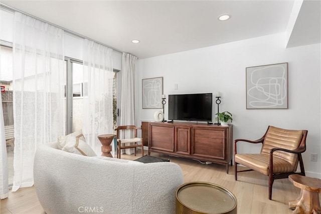living area with recessed lighting and light wood finished floors
