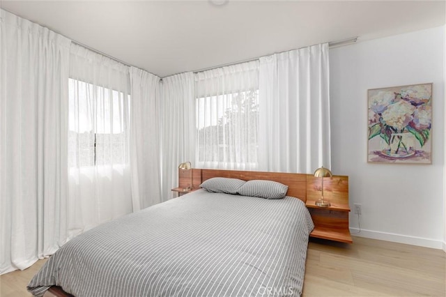 bedroom with baseboards and wood finished floors