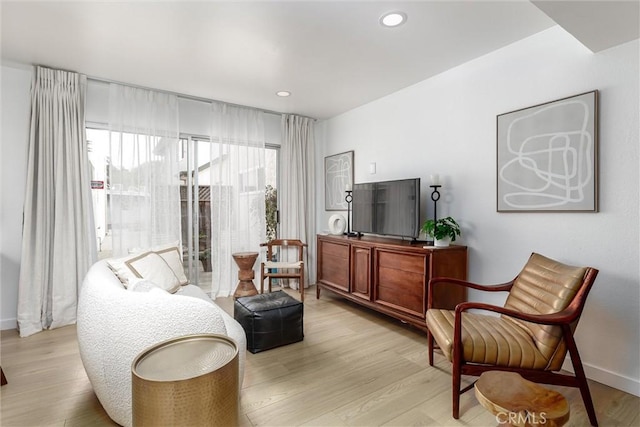living area with light wood-type flooring, recessed lighting, and baseboards