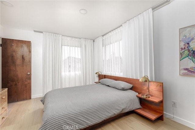 bedroom with light wood-style floors and baseboards