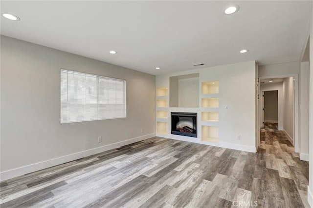 402 E Glendale Dr, Orange, CA 92865 - unfurnished living room featuring wood finished floors, recessed lighting, baseboards, built in features, and a glass covered fireplace