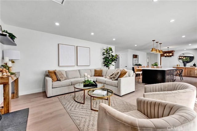 living room with light wood-style flooring, baseboards, and recessed lighting