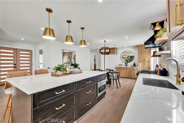 kitchen featuring recessed lighting, light wood-type flooring, a breakfast bar, and a sink