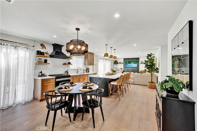 dining room with recessed lighting, light wood-type flooring, and an inviting chandelier