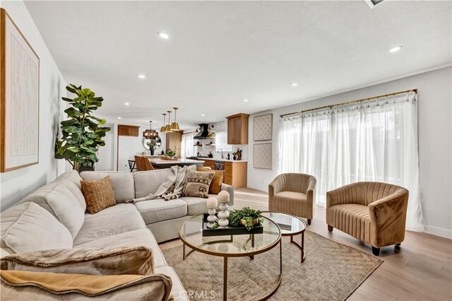 living room with light wood finished floors, baseboards, and recessed lighting