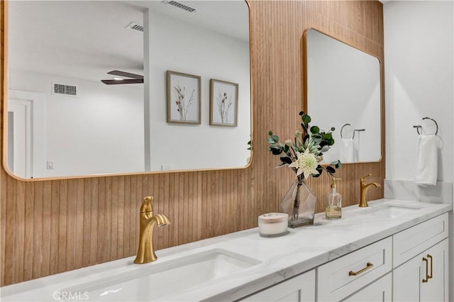full bath featuring ceiling fan, a sink, visible vents, and double vanity