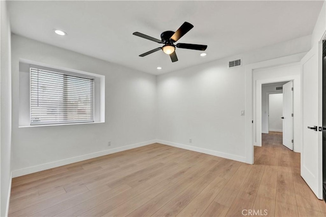 empty room featuring baseboards, a ceiling fan, light wood-style floors, and visible vents