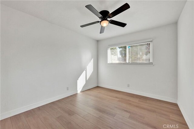 empty room featuring baseboards, wood finished floors, and ceiling fan