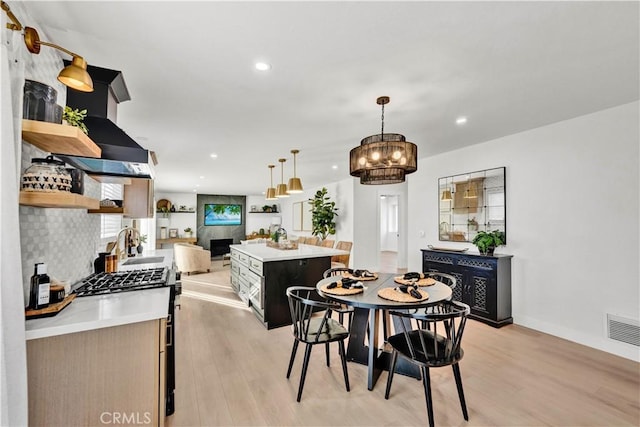dining space with light wood finished floors, visible vents, and recessed lighting