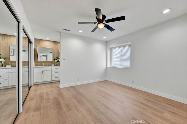 unfurnished bedroom featuring recessed lighting, visible vents, light wood-type flooring, ensuite bath, and baseboards