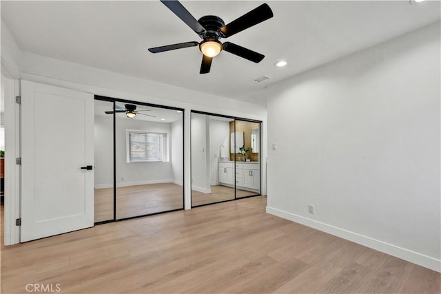 unfurnished bedroom with light wood finished floors, baseboards, recessed lighting, visible vents, and two closets
