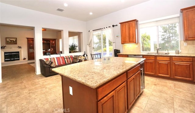 23801 Hollingsworth Dr, Murrieta, CA 92562 - kitchen with decorative backsplash, visible vents, a center island, a sink, and light stone counters