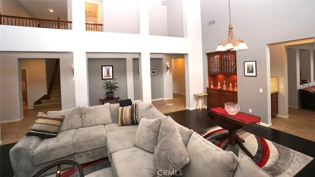 23801 Hollingsworth Dr, Murrieta, CA 92562 - living area with stairway, baseboards, a bar, a chandelier, and a high ceiling